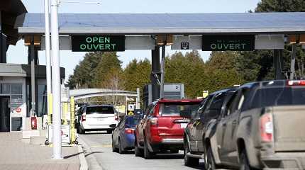 Drivers wait to cross through Canadian customs at the Canada