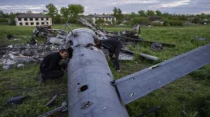 Oleksiy Polyakov and Roman Voitko check the remains of a destroyed Russian helicopter