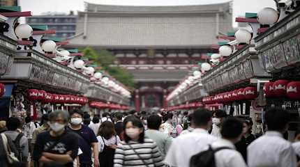 Visitors walk along a shopping street