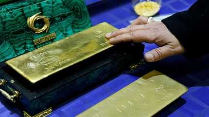 displays a gold bar at a gold refining workshop