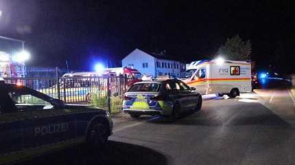 police and emergency services stand at an asylum seeker shelter after a knife attack