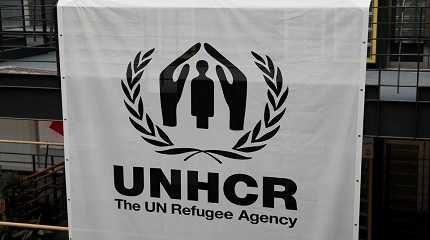 logo is pictured on a banner at the UNHCR