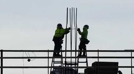 Construction workers work on a building