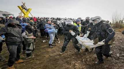 Police officers carry a demonstrator