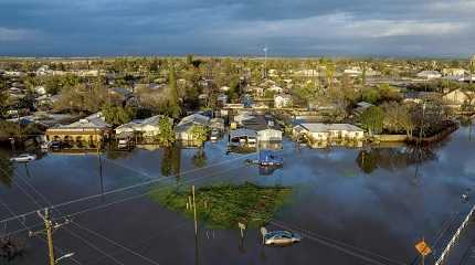 floodwaters surround homes and vehicles