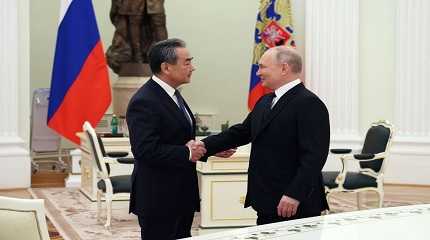 Vladimir Putin shakes hands Wang Yi 