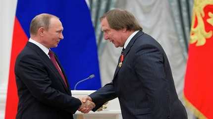 Vladimir Putin shakes hands with Sergei Roldugin