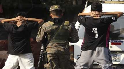 soldier checks the identification of youths