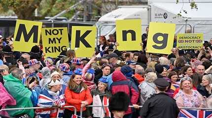 Protesters wave Not My King signs near to the King Procession