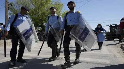 Riot police officers move to take positions