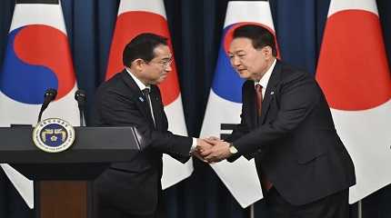 Yoon Suk Yeol shakes hands with Fumio Kishida