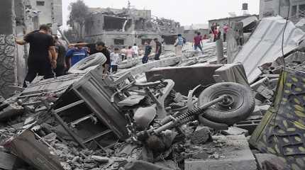 Palestinians walk about buildings destroyed