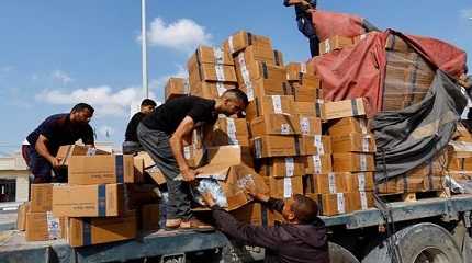 Palestinians reload a truck