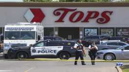 Police walk outside the Tops grocery store