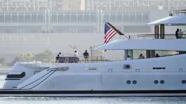 People look on from the super yacht Amadea 