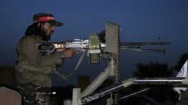 Taliban fighter stands guard at the site of an explosion