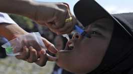 A girl receives drops of vaccine