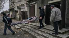 Local residents carry the body