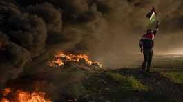 Palestinians burn tires and wave the national flag