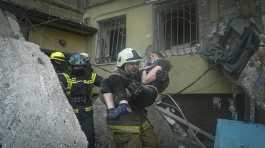 firefighter carries a wounded woman