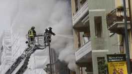 Firefighters work to extinguish a fire in a building after a van exploded