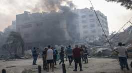 Palestinians inspect the rubble of building